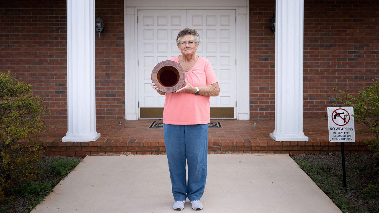 Jan Williams, who attends church with former President Jimmy Carter and taught his daughter fourth grade, poses in front of Maranatha Baptist Church in Plains with a collection plate Carter made.